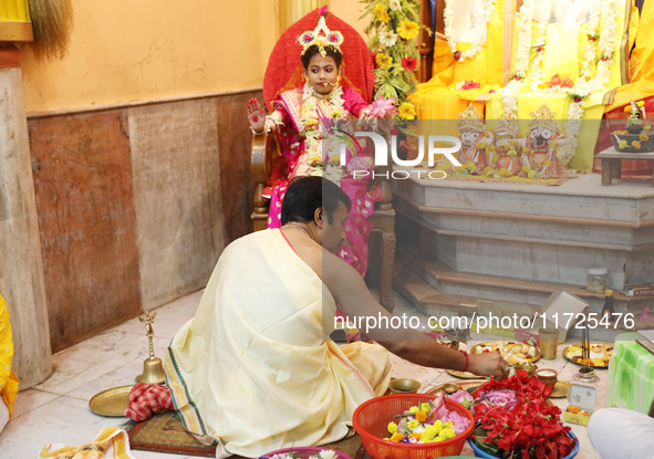 A Hindu priest offers prayer to Ridhima Jana, a 9-year-old girl dressed as a Kumari, who is worshiped by devotees during rituals to celebrat...