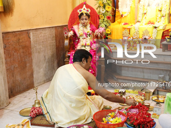 A Hindu priest offers prayer to Ridhima Jana, a 9-year-old girl dressed as a Kumari, who is worshiped by devotees during rituals to celebrat...