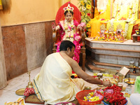 A Hindu priest offers prayer to Ridhima Jana, a 9-year-old girl dressed as a Kumari, who is worshiped by devotees during rituals to celebrat...