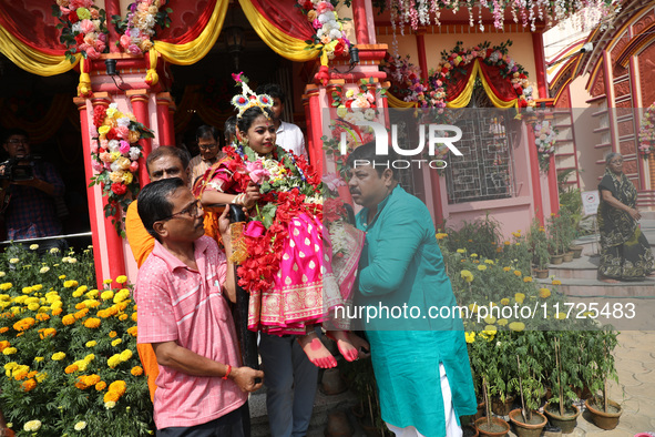 Devotees carry Ridhima Jana, a 9-year-old girl dressed as a Kumari, to give blessings after being worshipped by devotees as part of the ritu...