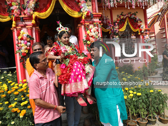 Devotees carry Ridhima Jana, a 9-year-old girl dressed as a Kumari, to give blessings after being worshipped by devotees as part of the ritu...