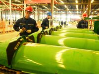 Construction workers assemble agricultural machinery at Jiufang Taihe International Heavy Industries (Qingdao) Co LTD in Qingdao, China, on...