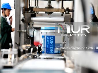 Workers produce lubricating oil on a production line at Qingdao Compton Technology Co LTD in Qingdao, Shandong province, China, on October 3...