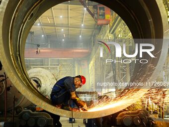 A construction worker builds petrochemical equipment at Lanshi Heavy Machinery Co LTD in Qingdao, China, on October 31, 2024. (