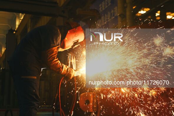 A construction worker builds petrochemical equipment at Lanshi Heavy Machinery Co LTD in Qingdao, China, on October 31, 2024. 