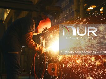 A construction worker builds petrochemical equipment at Lanshi Heavy Machinery Co LTD in Qingdao, China, on October 31, 2024. (