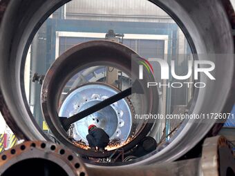 A construction worker builds petrochemical equipment at Lanshi Heavy Machinery Co LTD in Qingdao, China, on October 31, 2024. (