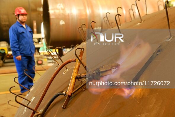 A construction worker builds petrochemical equipment at Lanshi Heavy Machinery Co LTD in Qingdao, China, on October 31, 2024. 