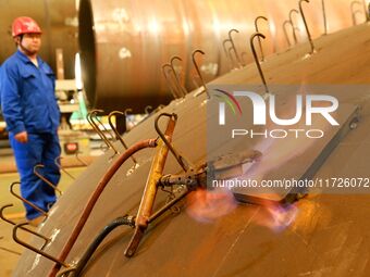 A construction worker builds petrochemical equipment at Lanshi Heavy Machinery Co LTD in Qingdao, China, on October 31, 2024. (