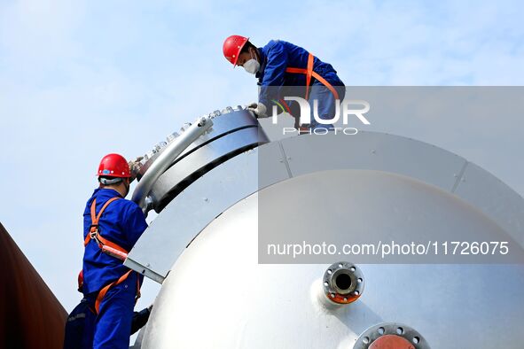 Construction workers assemble petrochemical equipment at Lanshi Heavy Machinery Co LTD in Qingdao, China, on October 31, 2024. 