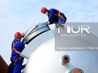 Construction workers assemble petrochemical equipment at Lanshi Heavy Machinery Co LTD in Qingdao, China, on October 31, 2024. (