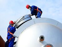 Construction workers assemble petrochemical equipment at Lanshi Heavy Machinery Co LTD in Qingdao, China, on October 31, 2024. (