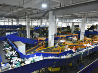 Workers use automatic sorting equipment to sort parcels at the Fuyang Mail Processing Center of China Post in Fuyang, China, on October 23,...