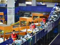 Workers use automatic sorting equipment to sort parcels at the Fuyang Mail Processing Center of China Post in Fuyang, China, on October 23,...