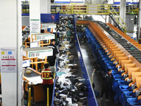 Workers use automatic sorting equipment to sort parcels at the Fuyang Mail Processing Center of China Post in Fuyang, China, on October 23,...