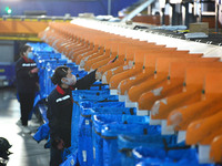 Workers use automatic sorting equipment to sort parcels at the Fuyang Mail Processing Center of China Post in Fuyang, China, on October 23,...