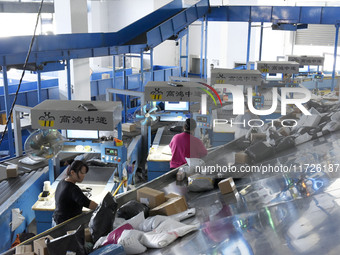 Staff members of the ZTO Express Fuyang Distribution Center use automatic sorting equipment to sort parcels in Fuyang, China, on October 23,...