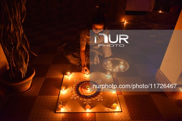 A woman lights earthen oil lamps during the celebrations to mark Diwali, the Hindu festival of lights, in Nagaon District, Assam, India, on...