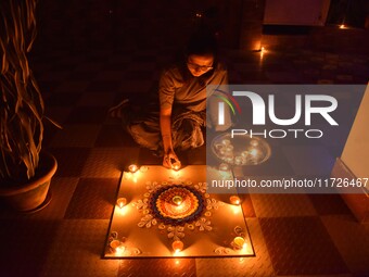 A woman lights earthen oil lamps during the celebrations to mark Diwali, the Hindu festival of lights, in Nagaon District, Assam, India, on...