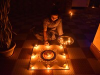 A woman lights earthen oil lamps during the celebrations to mark Diwali, the Hindu festival of lights, in Nagaon District, Assam, India, on...