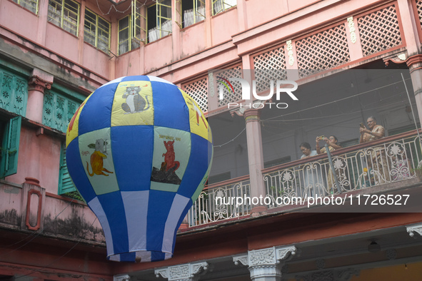 Women take photos during The Fanush (a paper-made hot air balloon) festival inside an old house to mark the Diwali festival in Kolkata, Indi...