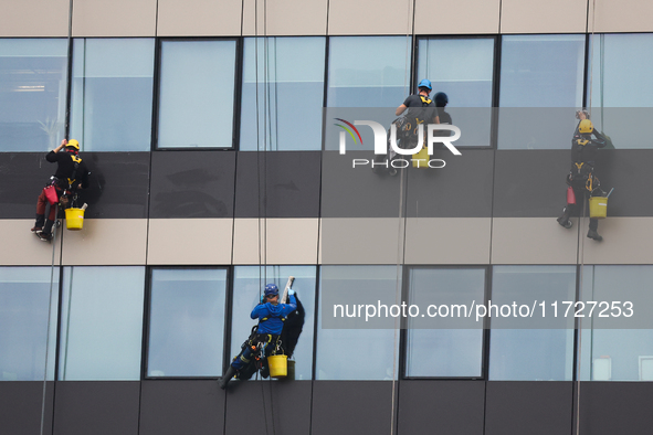 High rise window cleaners work at the office building in Krakow, Poland on October 31, 2024. 