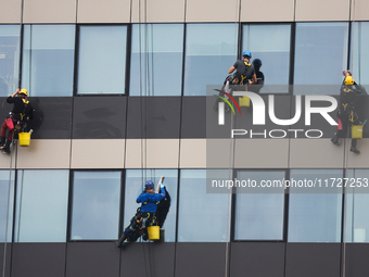 High rise window cleaners work at the office building in Krakow, Poland on October 31, 2024. (