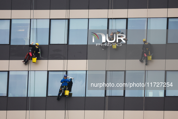 High rise window cleaners work at the office building in Krakow, Poland on October 31, 2024. 