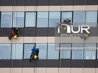 High rise window cleaners work at the office building in Krakow, Poland on October 31, 2024. (