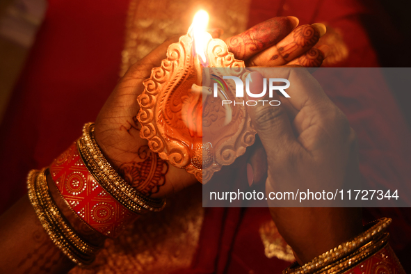 A Hindu devotee holds a diya (small clay lamp) during the festival of Diwali at a Hindu temple in Toronto, Ontario, Canada, on October 31, 2...