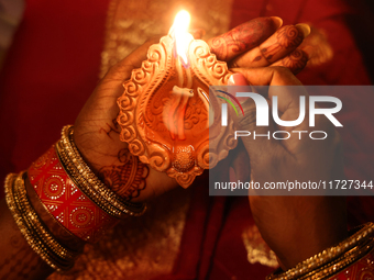 A Hindu devotee holds a diya (small clay lamp) during the festival of Diwali at a Hindu temple in Toronto, Ontario, Canada, on October 31, 2...