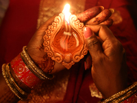 A Hindu devotee holds a diya (small clay lamp) during the festival of Diwali at a Hindu temple in Toronto, Ontario, Canada, on October 31, 2...