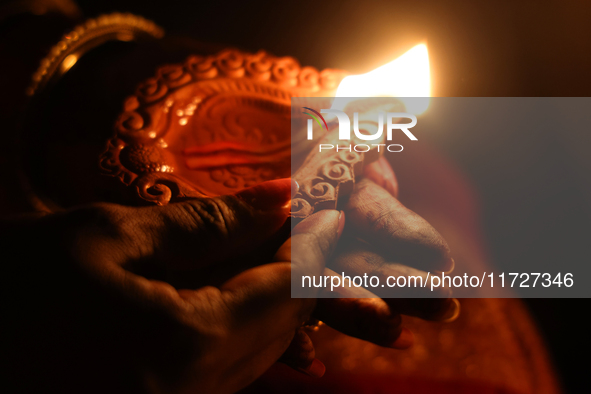 A Hindu devotee holds a diya (small clay lamp) during the festival of Diwali at a Hindu temple in Toronto, Ontario, Canada, on October 31, 2...