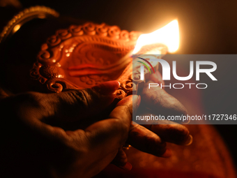 A Hindu devotee holds a diya (small clay lamp) during the festival of Diwali at a Hindu temple in Toronto, Ontario, Canada, on October 31, 2...