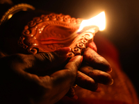 A Hindu devotee holds a diya (small clay lamp) during the festival of Diwali at a Hindu temple in Toronto, Ontario, Canada, on October 31, 2...