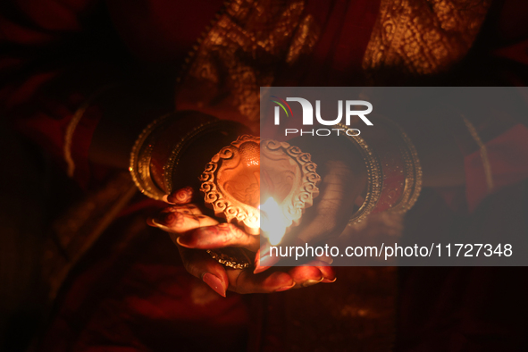 A Hindu devotee holds a diya (small clay lamp) during the festival of Diwali at a Hindu temple in Toronto, Ontario, Canada, on October 31, 2...