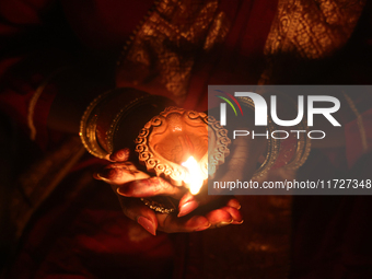 A Hindu devotee holds a diya (small clay lamp) during the festival of Diwali at a Hindu temple in Toronto, Ontario, Canada, on October 31, 2...