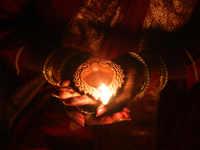 A Hindu devotee holds a diya (small clay lamp) during the festival of Diwali at a Hindu temple in Toronto, Ontario, Canada, on October 31, 2...