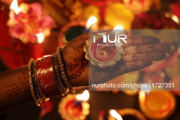 A Hindu devotee holds a diya (small clay lamp) during the festival of Diwali at a Hindu temple in Toronto, Ontario, Canada, on October 31, 2...