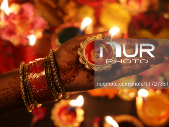 A Hindu devotee holds a diya (small clay lamp) during the festival of Diwali at a Hindu temple in Toronto, Ontario, Canada, on October 31, 2...