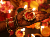 A Hindu devotee holds a diya (small clay lamp) during the festival of Diwali at a Hindu temple in Toronto, Ontario, Canada, on October 31, 2...