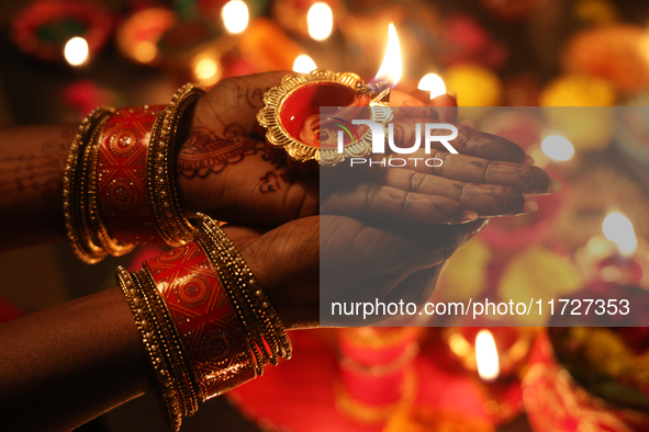 A Hindu devotee holds a diya (small clay lamp) during the festival of Diwali at a Hindu temple in Toronto, Ontario, Canada, on October 31, 2...