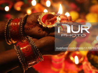 A Hindu devotee holds a diya (small clay lamp) during the festival of Diwali at a Hindu temple in Toronto, Ontario, Canada, on October 31, 2...