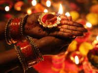 A Hindu devotee holds a diya (small clay lamp) during the festival of Diwali at a Hindu temple in Toronto, Ontario, Canada, on October 31, 2...