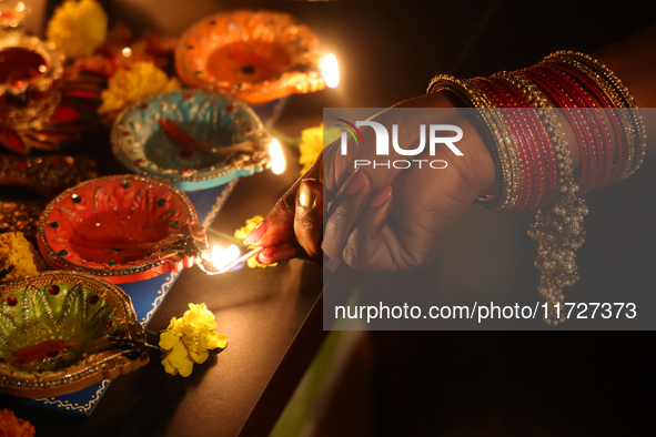 A Hindu devotee lights diyas (small clay lamps) during the festival of Diwali at a Hindu temple in Toronto, Ontario, Canada, on October 31,...