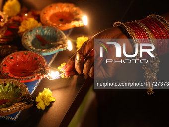 A Hindu devotee lights diyas (small clay lamps) during the festival of Diwali at a Hindu temple in Toronto, Ontario, Canada, on October 31,...