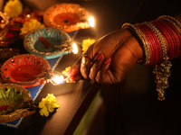 A Hindu devotee lights diyas (small clay lamps) during the festival of Diwali at a Hindu temple in Toronto, Ontario, Canada, on October 31,...