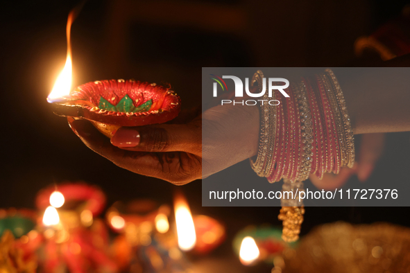 A Hindu devotee holds a diya (small clay lamp) during the festival of Diwali at a Hindu temple in Toronto, Ontario, Canada, on October 31, 2...