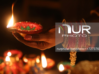 A Hindu devotee holds a diya (small clay lamp) during the festival of Diwali at a Hindu temple in Toronto, Ontario, Canada, on October 31, 2...