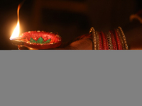 A Hindu devotee holds a diya (small clay lamp) during the festival of Diwali at a Hindu temple in Toronto, Ontario, Canada, on October 31, 2...